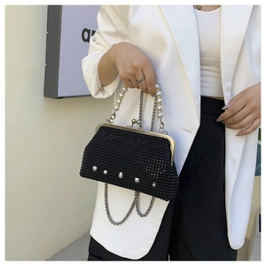 Detail of vintage black evening bag with sparkling rhinestones and pearl handle
