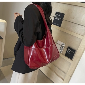 Close-up of a large burgundy PU leather hobo bag with contrast stitching and side pocket