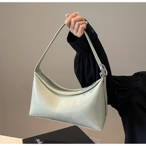 Detail of mint green PU leather underarm bag with silver hardware and smooth zipper