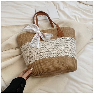 Handwoven straw tote bag with brown stripes, leather handles and floral lace bow decoration