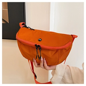 Detail of bright orange washed canvas crossbody bag with thick zippers and adjustable strap