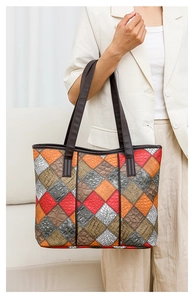 Detail of colorful patchwork tote bag featuring crocodile and lizard textured faux leather
