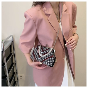 Detail of crossbody evening bag with heart pattern rhinestones and pearl handle