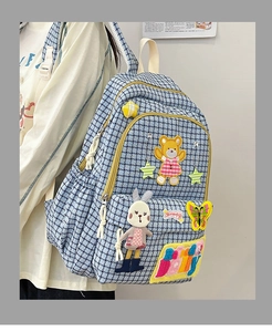 Detail of blue plaid nylon backpack with cute cartoon bear and bunny embroidery patches