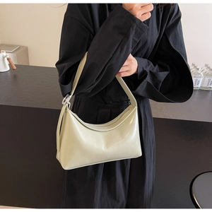 Detailed view of glossy light green PU leather texture and silver buckle on shoulder bag