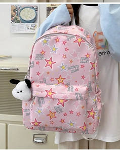 Detailed shot of pink nylon backpack with star pattern and cute plush puppy charm