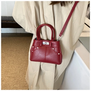 Detailansicht der weinroten PU-Ledertasche mit Lychee-Muster und silbernen Metallteilen