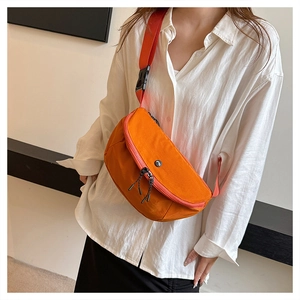 Detail view of the bright orange nylon crescent crossbody bag with adjustable strap