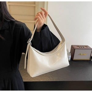 Detail of white moon-shaped PU hobo bag with silver buckle and smooth wax leather texture