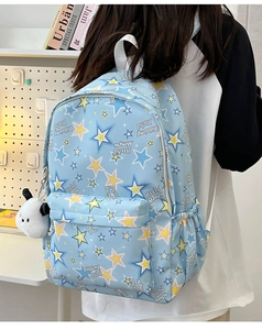 Detail of light blue nylon backpack featuring star print and cute dog plush charm accessory