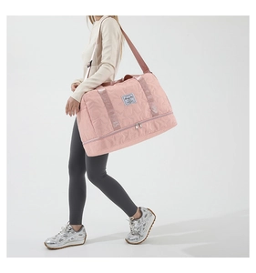 Pink travel bag detail featuring star quilting, dual handles, and independent bottom shoe compartment