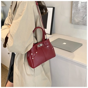 Detailansicht der weinroten PU-Ledertasche mit Lychee-Muster und silbernem Drehverschluss