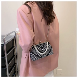 Detail showing the vintage rhinestone crossbody bag with pearl handle and heart pendant
