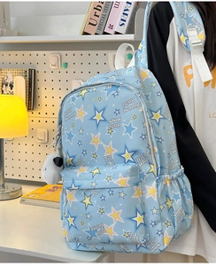 Close-up of light blue nylon star pattern backpack with a cute panda plush charm