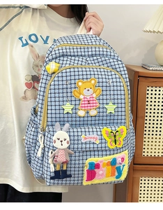 Close-up of light blue houndstooth backpack with cute cartoon embroidery patches