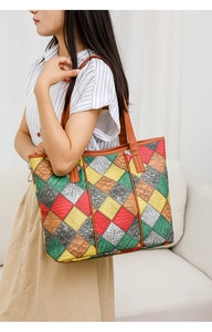 Detail of multi-color patchwork tote bag with crocodile texture and leather shoulder strap
