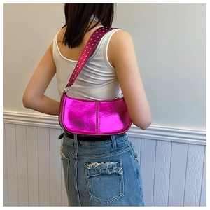 Détail du sac à bandoulière rose métallisé avec rivets ronds argentés sur la sangle