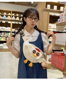 Détail du sac bandoulière en nylon crème en forme de poulet avec peluche d'ours