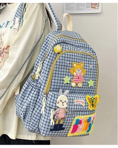 Detail of light blue houndstooth nylon backpack with cartoon bear and rabbit patches
