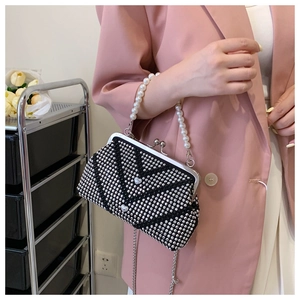 Detail of elegant black rhinestone evening bag with V-pattern and heart accents