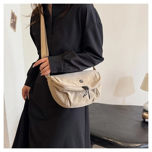 Beige crescent nylon crossbody bag with textured fabric and adjustable shoulder strap