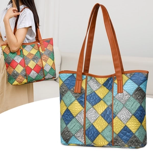 Detail of colorful patchwork tote bag with crocodile and snake textures and long straps
