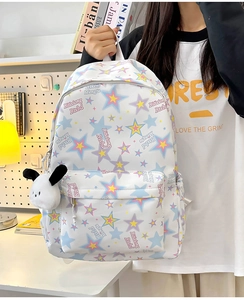 Detail view of white nylon star pattern backpack with a cute plush puppy charm