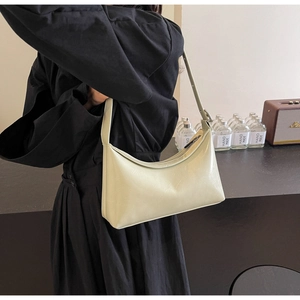 Detail view of light green glossy PU leather crescent underarm bag with adjustable strap