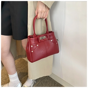 Detaillierte Nahaufnahme der roten PU-Handtasche mit Litschimuster und silbernem Drehverschluss