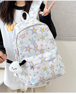 Close-up of minimalist nylon backpack with colorful star pattern and plush dog charm