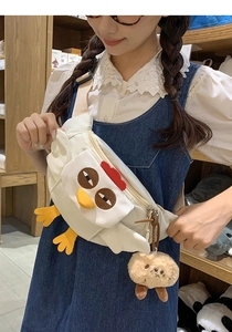 Détail du sac bandoulière poussin blanc avec éléments 3D et porte-clé en peluche