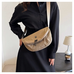 Khaki crescent nylon crossbody bag with pleated finish and wide strap on model