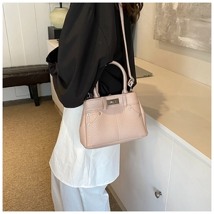 Detail der altrosa Lederhandtasche mit Silbernieten und Metall-Drehverschluss