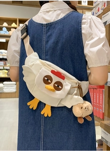 Détail du sac bandoulière poussin blanc avec crête rouge et breloque chiot mignon