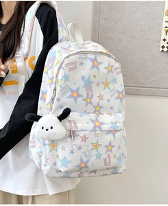 Macro detail of white nylon backpack with colorful stars and a cute dog plush keychain