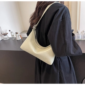 Detail of light green PU crescent shoulder bag worn by model in a stylish lifestyle setting