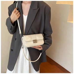 Close-up of minimalist white patent leather crossbody bag with silver square metal clasp