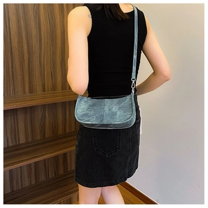 Détail du sac à bandoulière en PU bleu délavé avec texture métallique et crochets argentés