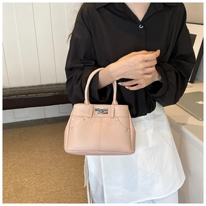 Detail der rosa PU-Lederhandtasche mit Lychee-Textur und metallischem Drehverschluss