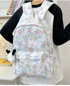 Detailed view of white nylon backpack with colorful stars and a plush puppy keychain