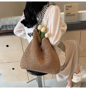 Détail du sac bandoulière en paille tressée avec sangle rayée et espace intérieur