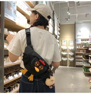 Détail du sac bandoulière en nylon poussin noir avec pieds et ailes de poulet en peluche