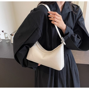 Detail of minimalist beige PU leather underarm bag with silver round buckle adjustment