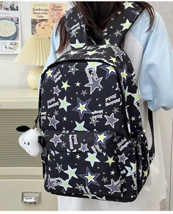 Detail of nylon star pattern backpack with side pocket and white puppy plush keychain