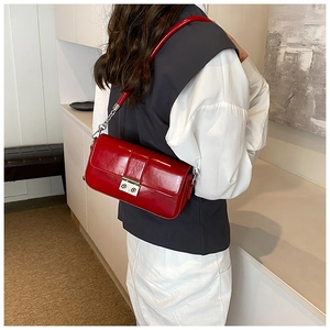 Detail view of stylish red PU leather baguette bag with silver chain strap and metal buckle
