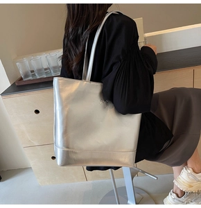Silver metallic PU leather tote bag with bow detail shown on model in daily setting