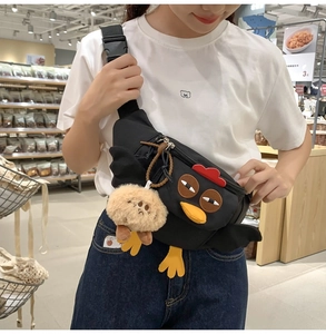 Détail du sac à bandoulière en nylon noir avec crête rouge 3D et pendentif peluche