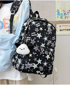 Detail view of black nylon star pattern backpack with a cute white dog plush pendant