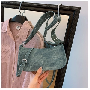 Gros plan d'un sac porté épaule en denim rétro avec rivets argentés sur la sangle