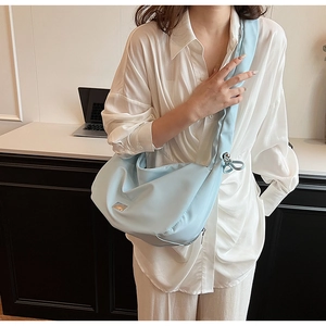 Detail of light blue crescent bag with smooth fabric and silver metal hardware